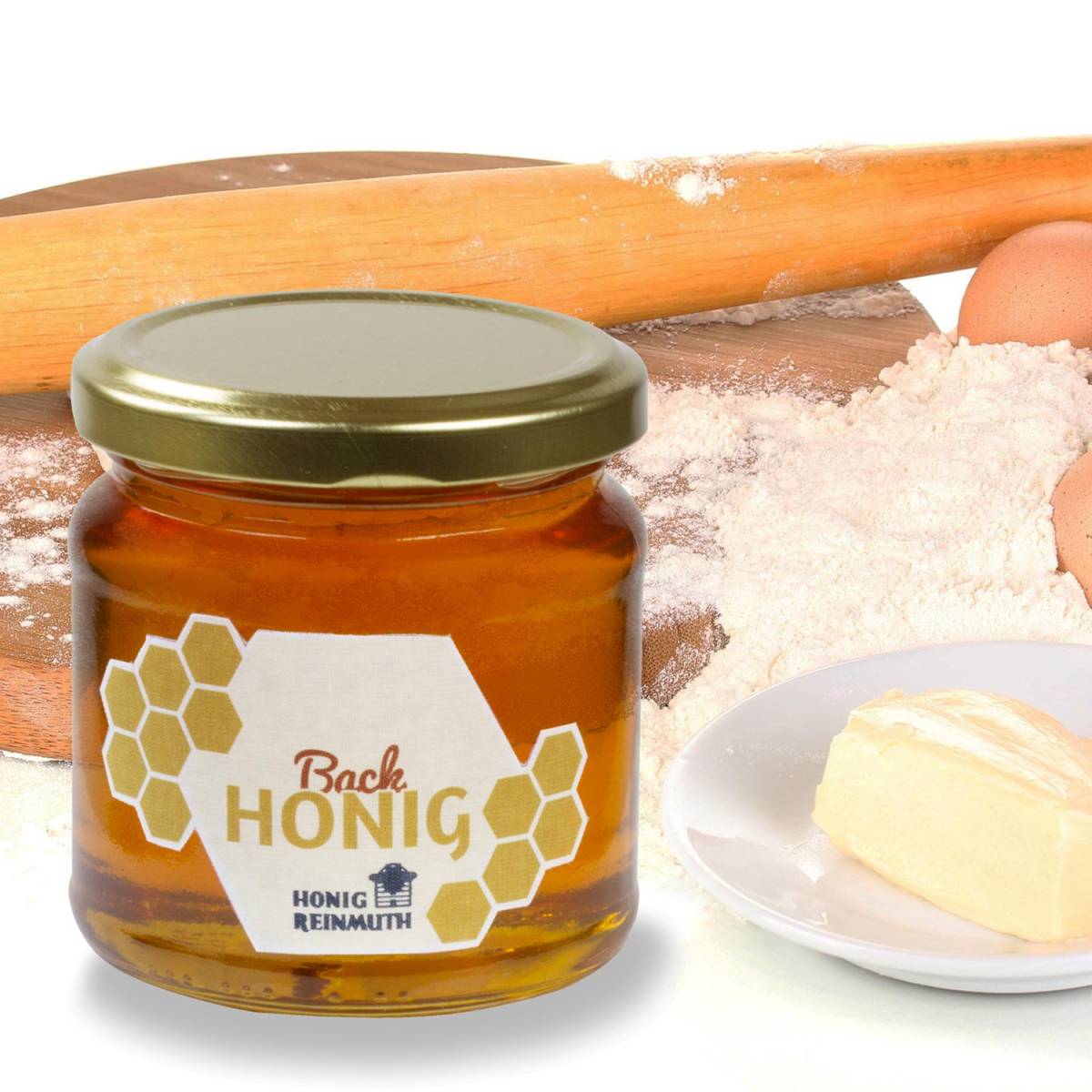 Backhonig im Glas vor Butter, Mehl und Eiern