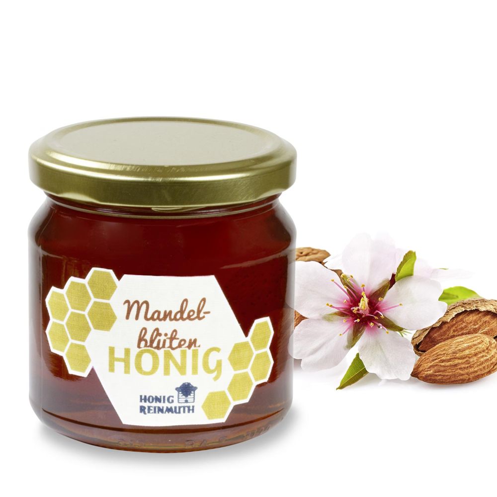 Mandelblütenhonig im Glas vor Mandeln und Mandelblüten