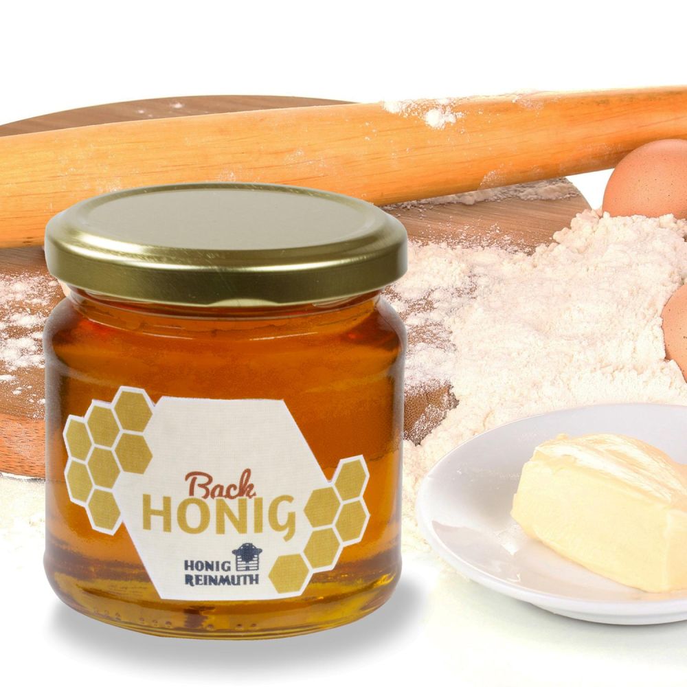 Backhonig im Glas vor Butter, Mehl und Eiern